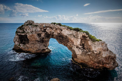 Rock formation in sea against sky