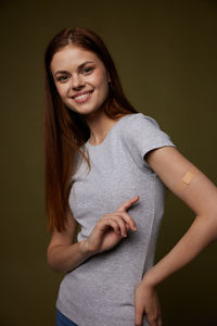 Portrait of young woman with arms raised