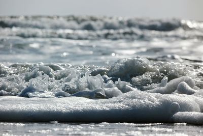 Close-up of glacier in sea against sky