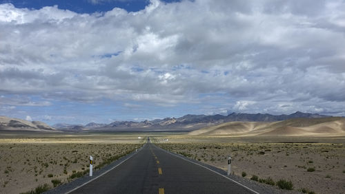  flat newly built unmanned asphalt road leads to the foot of the distant mountain