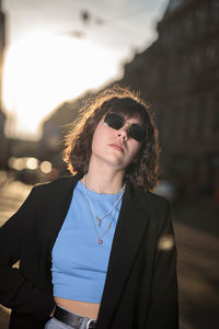 Portrait of young woman wearing sunglasses standing outdoors