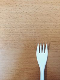 Directly above shot of plastic fork on wooden table