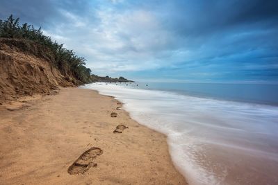 Footprints at shore of beach