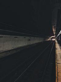 Railway tracks at railroad station at night