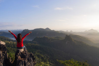 Woman standing on mountain against sky