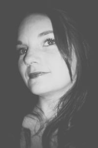 Close-up portrait of young woman over black background