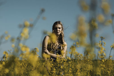 Young woman with yellow flower in field