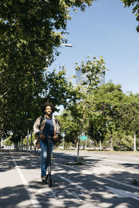 Man with backpack riding his e-scooter on a bicycle lane