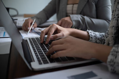 Midsection of woman using laptop