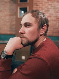 Young man looking away against wall