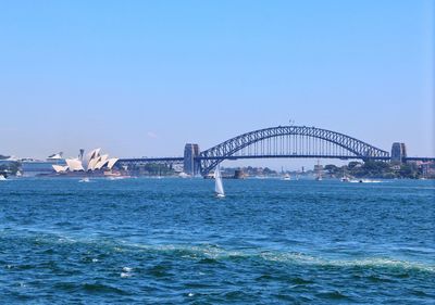 Bridge over sea against clear blue sky