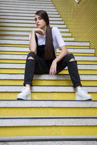 Full length of teenage girl sitting on staircase 