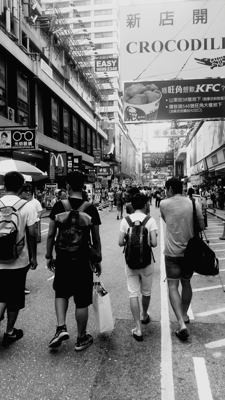 men, street, walking, person, lifestyles, city, large group of people, city life, building exterior, architecture, market, casual clothing, built structure, full length, rear view, leisure activity, umbrella, retail, standing