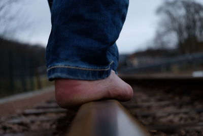 Low section of man standing on railroad track