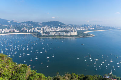 High angle view of city by sea against sky