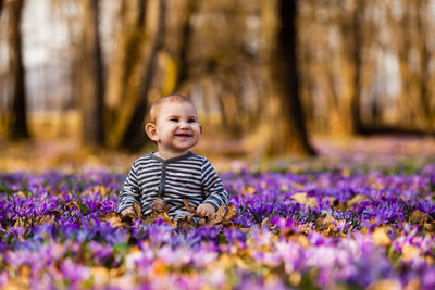 Portrait of smiling girl standing on purple flowering plants
