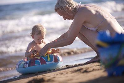 Portrait of boy playing with toy on sand at beach