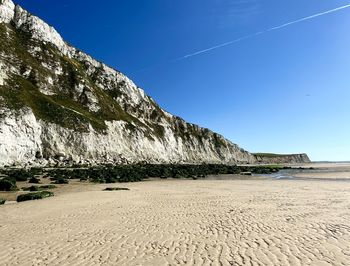 Scenic view of beach against clear blue sky