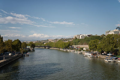 River amidst city against sky