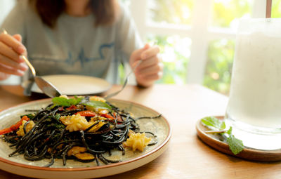 Black cuttlefish ink spaghetti with shrimp on plate. black pasta with squid ink on a restaurant 