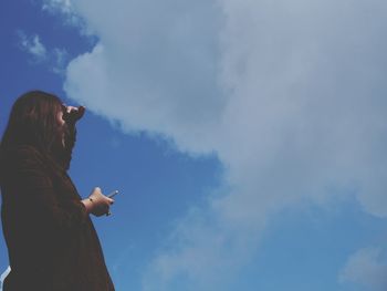 Low angle view of woman standing against sky