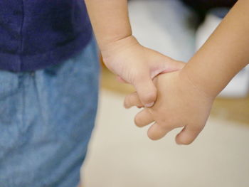 Close-up of siblings holding hands