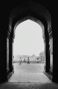 People walking in archway of historical building
