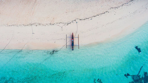 High angle view of outrigger moored on shore at beach