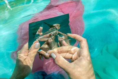 High angle view of woman holding hands in swimming pool