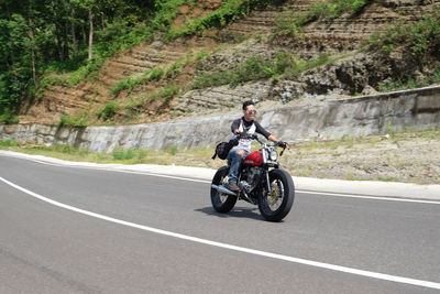 Woman riding motorcycle on road