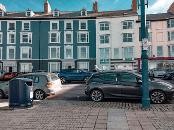 Cars on road by buildings in city