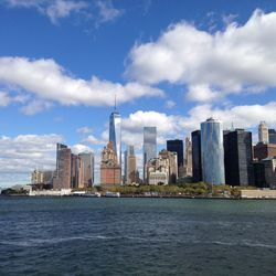 Sea by buildings against sky in city