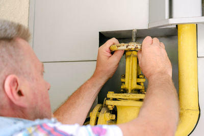 Man opens or closes on a gas pipe valve to control gases entering the system. close-up.