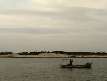 Man sailing on sea against sky