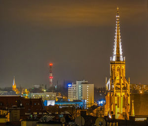 Illuminated buildings in city against sky at night