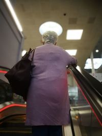 Rear view of woman standing in bus