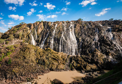 Scenic view of waterfall against sky