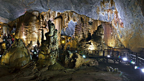 Panoramic view of illuminated building in cave