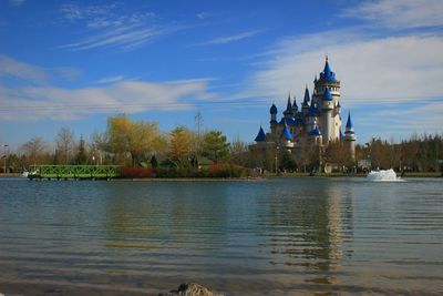 Scenic view of river by building against sky