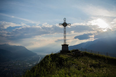 Cross on mountain against sky