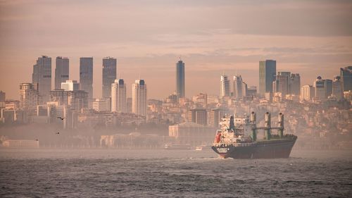 Boat in sea against buildings in city