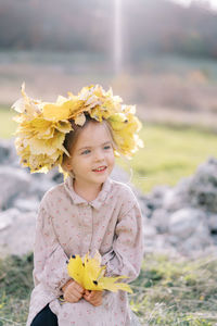 Portrait of young woman standing against trees