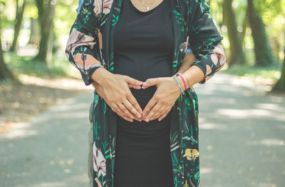 Midsection of woman holding umbrella while standing on land