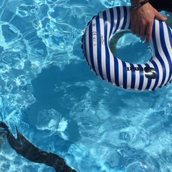 Human hand holding rubber ring in the pool