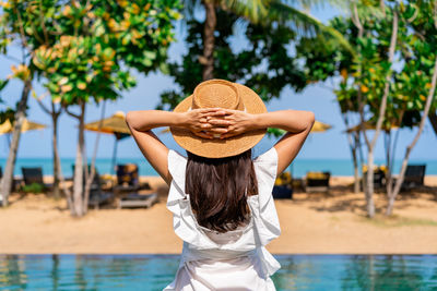Rear view of woman wearing hat at beach