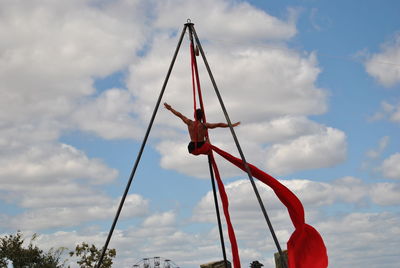 Low angle view of acrobat performing against sky