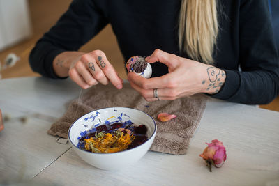 Midsection of woman holding food on table