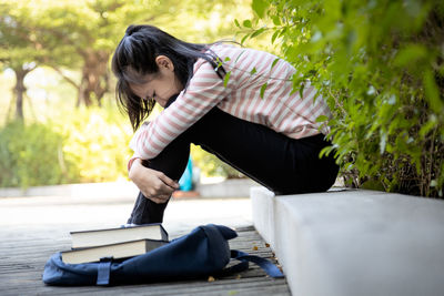 Full length of woman sitting outdoors