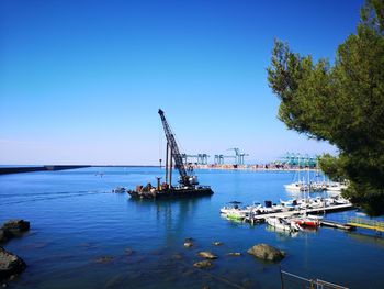 Ship in sea against clear blue sky