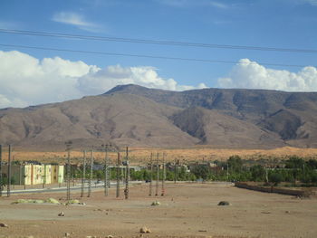 Scenic view of field and mountains against sky